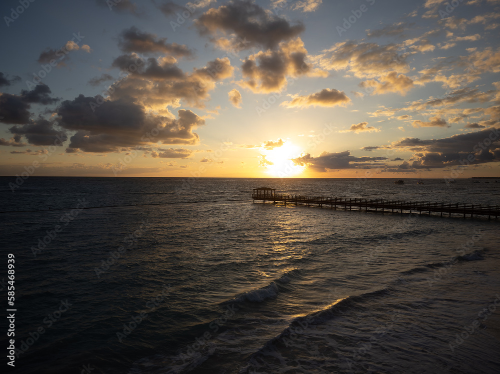 Obraz premium Cloudy sky over the sea at dusk. Wooden pier over dark water. Dramatic sky. Nature, ecology, climate, environmental protection.
