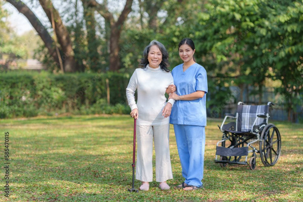 Asian nurse or female caregiver helping senior woman holding cane to walk in the hospital garden. Asian nurse or female caregiver helping senior woman holding cane to walk in the hospital garden.