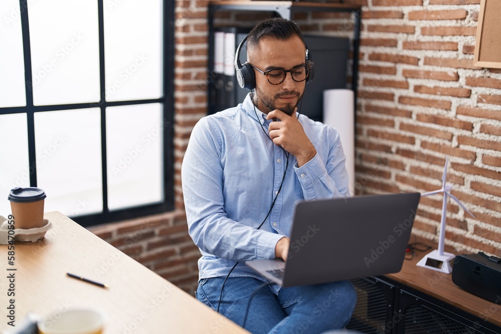 Young hispanic man business worker using laptop and headphones at office Young hispanic man business worker using laptop and headphones at office