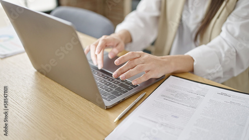 Young beautiful hispanic woman using laptop at office