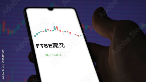 Investor analyzing an ETF. Funds stocks exchange ETFs Japanese text: ftse development, buy. FTSE開発 証券取引所 投資 shares