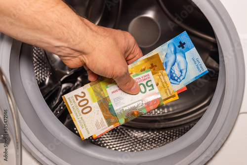 Swiss francs thrown into the washing machine, Concept, Money laundering, illegal activity, black market, Criminal activity