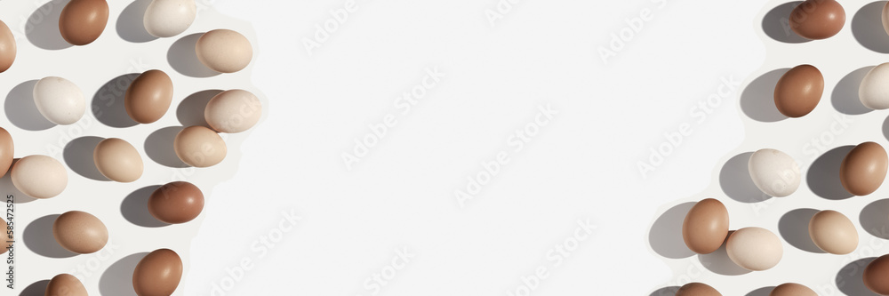 Painted Easter eggs beige brown color gradient on white background, long banner with copy space, dark shadow at sunlight. Minimal aesthetic flat lay from Chicken eggs, Easter holiday food Painted Easter eggs beige brown color gradient on white background, long banner with copy space, dark shadow at sunlight. Minimal aesthetic flat lay from Chicken eggs, Easter holiday food