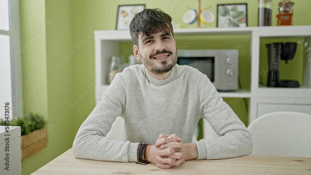 Young hispanic man smiling confident sitting on the sable at dinning room Young hispanic man smiling confident sitting on the sable at dinning room
