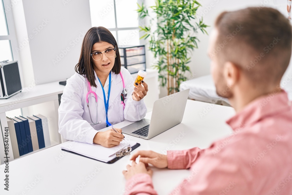 Man and woman doctor and patient having medical consultation prescribe pills at clinic Man and woman doctor and patient having medical consultation prescribe pills at clinic