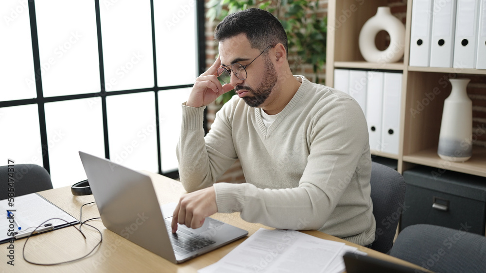 Young hispanic man business worker using laptop working at office
