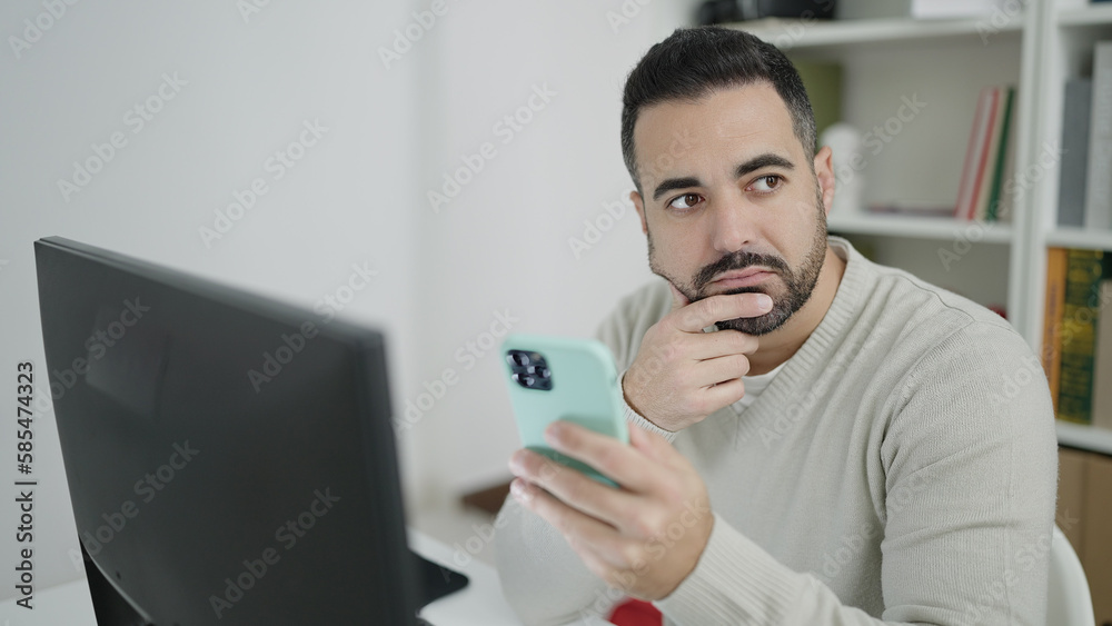 Young hispanic man student using computer and smartphone at library university Young hispanic man student using computer and smartphone at library university