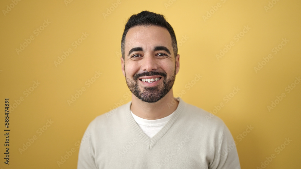 Young hispanic man smiling confident standing over isolated yellow background Young hispanic man smiling confident standing over isolated yellow background