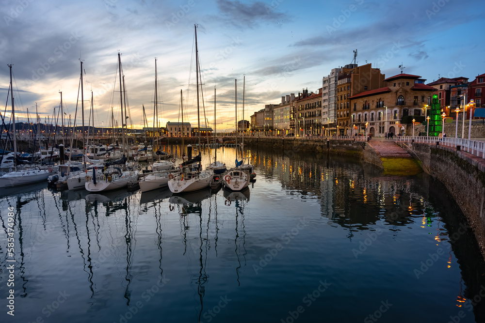 Marina at sunset with promenade and sailing boats in the tourist city of Gijon, Asturias.