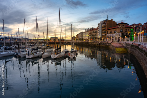 Marina at sunset with promenade and sailing boats in the tourist city of Gijon, Asturias.