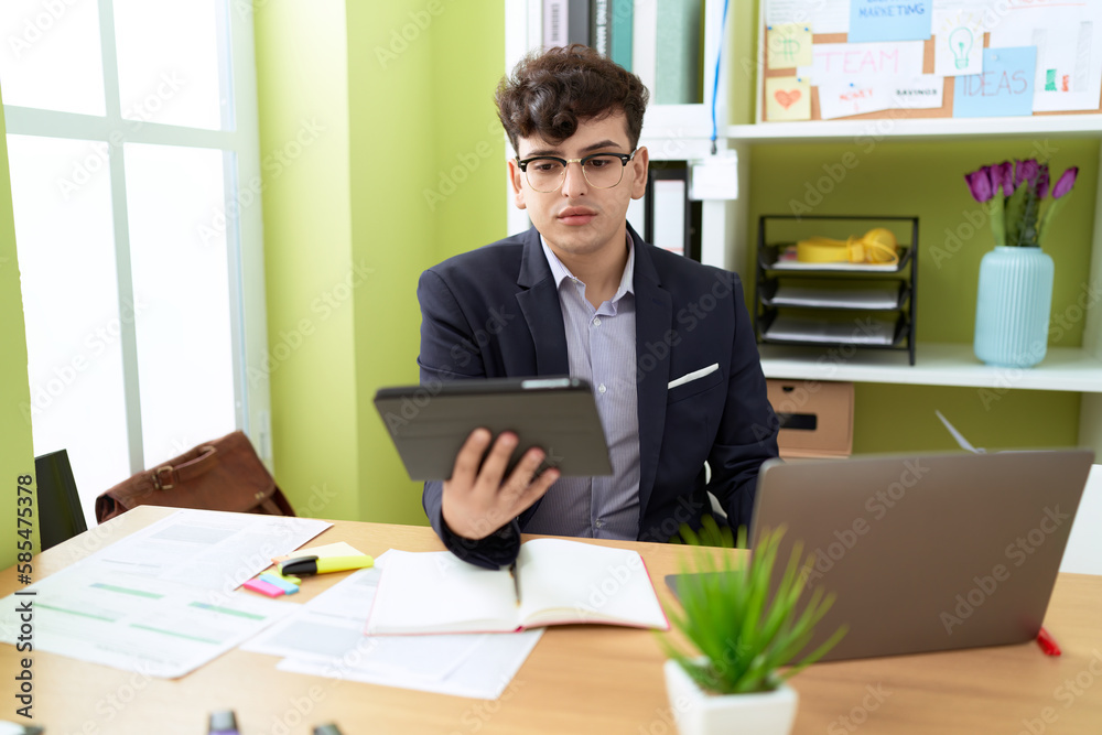 Non binary man business worker using touchpad and laptop at office Non binary man business worker using touchpad and laptop at office