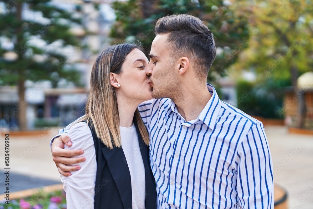 Fototapeta premium Man and woman couple hugging each other kissing at park