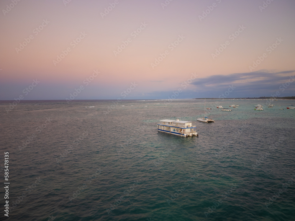 Obraz premium White yacht and boats in the sea. Shooting from the air. Twilight. The sea is calm. Romance. Boat trips, tourism, fishing, seaside resort.