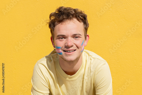 transgender man with transgender flag painted on his face photo