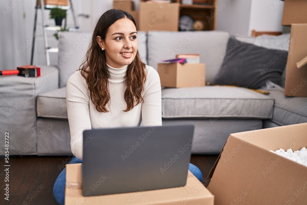 Young beautiful hispanic woman smiling confident using laptop at new home Young beautiful hispanic woman smiling confident using laptop at new home