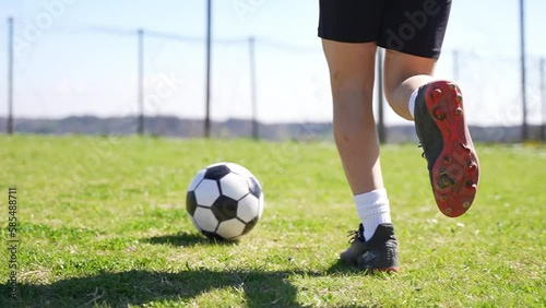 The camera follows a young soccer child player moving forward with the ball.