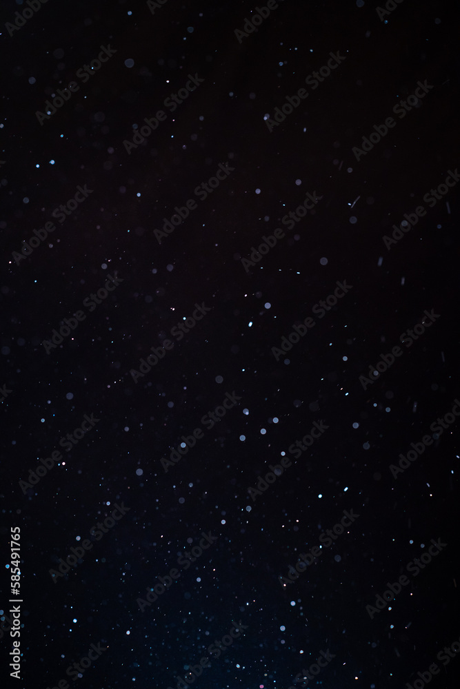 Fototapeta premium Natural organic dust particles floating on a sunbeam on black background. Glittering sparkling flickering in space 3D illustration. High Quality Vertical Photo
