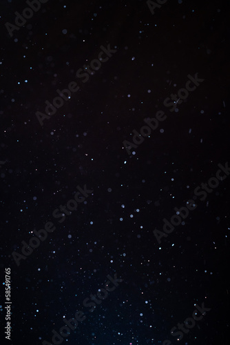 Natural organic dust particles floating on a sunbeam on black background. Glittering sparkling flickering in space 3D illustration. High Quality Vertical Photo