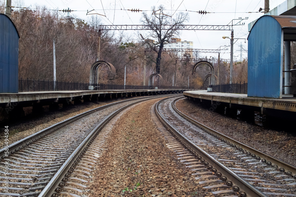 Obraz premium Åmpty train station and deserted platform in a small town. Autumn train station. Railroad tracks.