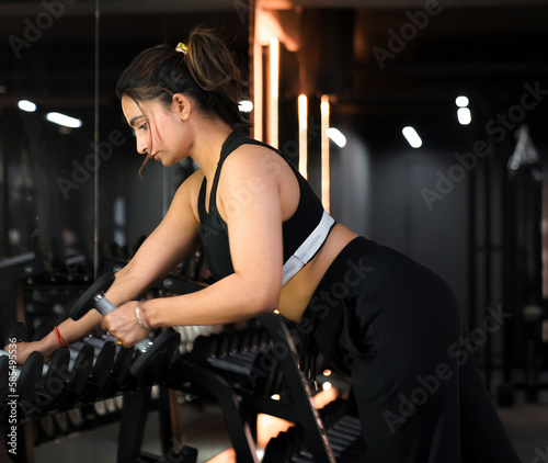 Single Arm Dumbbell Row Upper Back Workout by Young Indian Fit Gym Girl in Black Sportswear