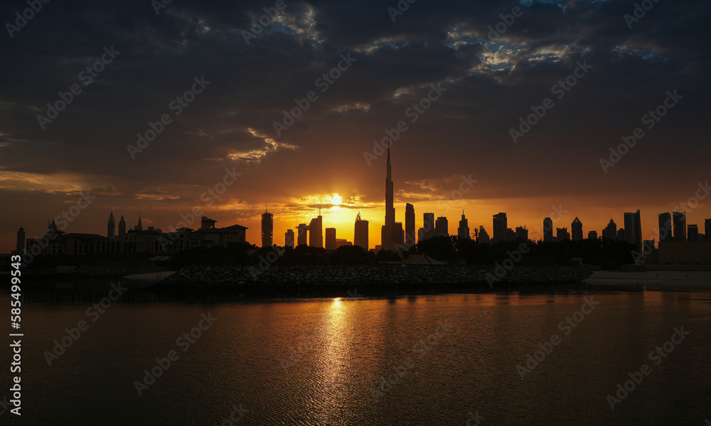 Rays of sun bursting in spectacular sunrise landscape in United Arab Emirates. Amazing silhouette sunrise sky in Dubai, view to Burj Khalifa and the entire skyline with modern skyscrapers buildings.