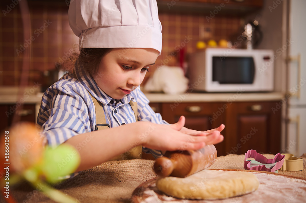 Adorable little boy and his mom in white aprons cooking together in the  kitchen Stock Photo