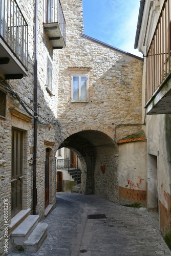 Fototapeta Naklejka Na Ścianę i Meble -  A narrow street among the old houses of Pietramontecorvino, a medieval village in the state of Puglia in Italy.