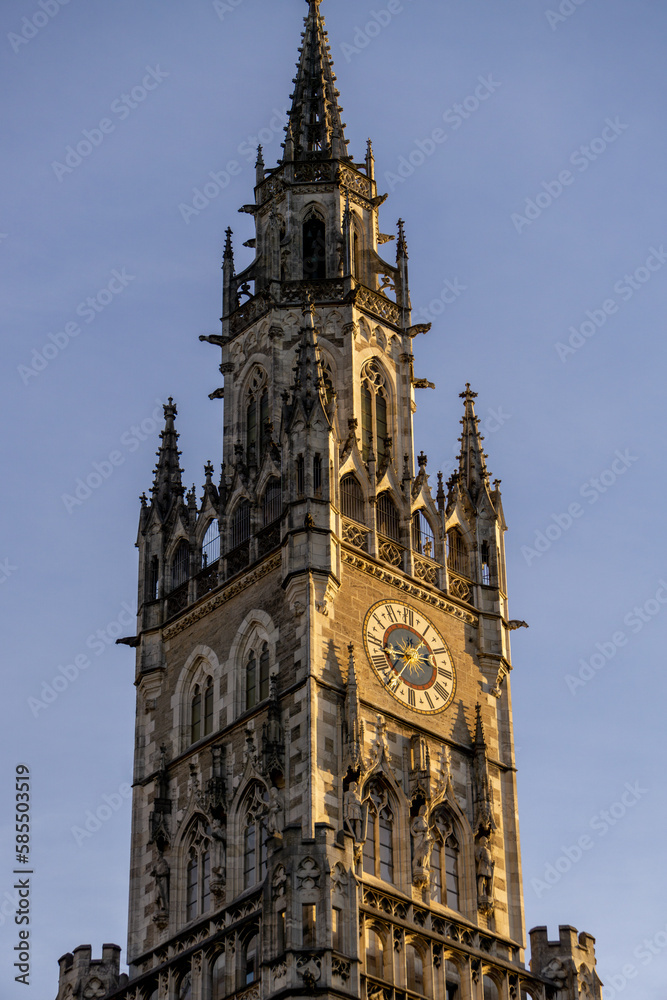 View of the clock tower of the new town hall in Munich, at sunrise on a sunny day.