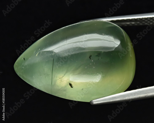 Natural gemstone green prehnite on gray background photo