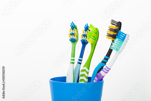 Toothbrush in a plastic cup on white background.