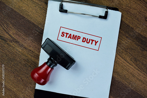 Concept of Red Handle Rubber Stamper and Stamp Duty text isolated on on Wooden Table. photo