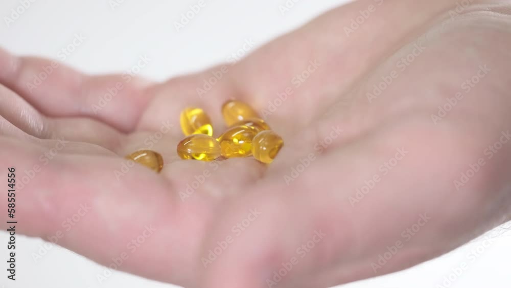 The man pour out from the jar omega 3 vitamin capsules to his palm. Omega-3 fatty acids support the health of joints and bones, prevent the development of arthrosis. The man pour out from the jar omega 3 vitamin capsules to his palm. Omega-3 fatty acids support the health of joints and bones, prevent the development of arthrosis.