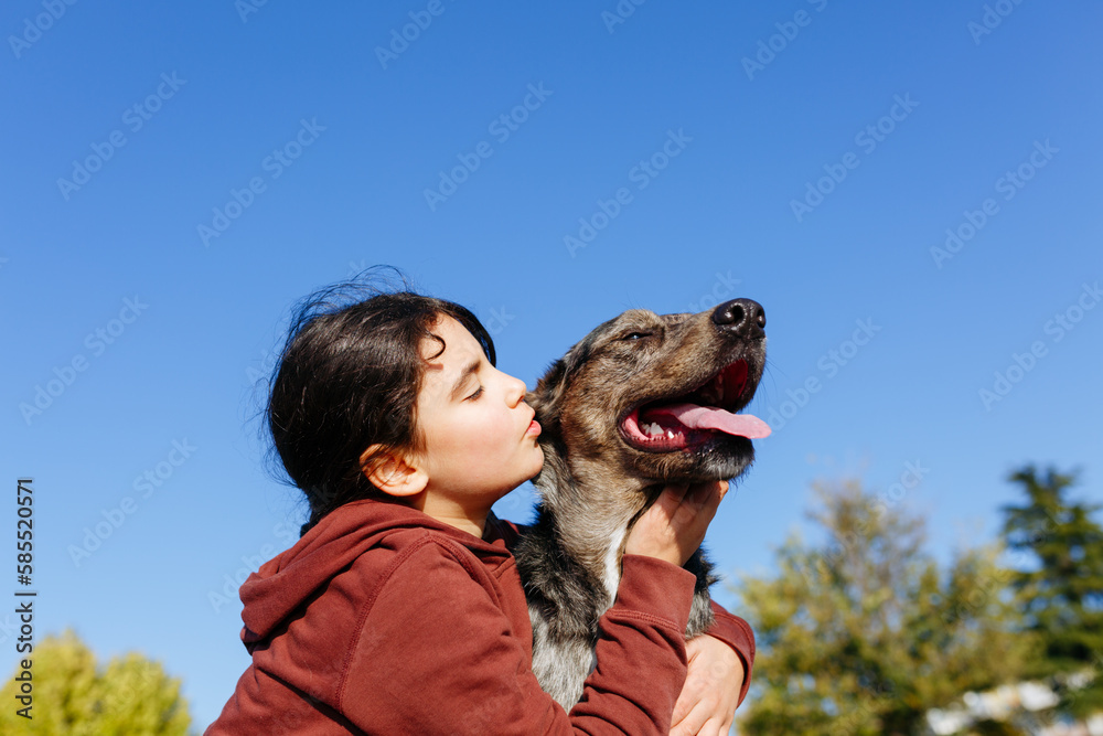 Αυτοκόλλητο Girl with dark hair kisses her grey dog