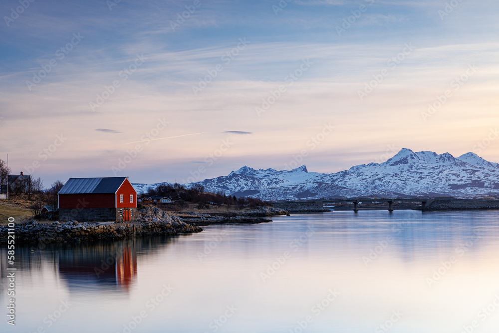 lake and mountains with red barn at lofoten norway