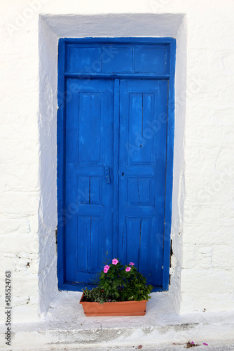 Vacation destination Chios Greece: typical Greek blue wooden doors and shutters on white wall in Volissos in the north of the Aegean island. Attractive place to be, with few tourists so far.