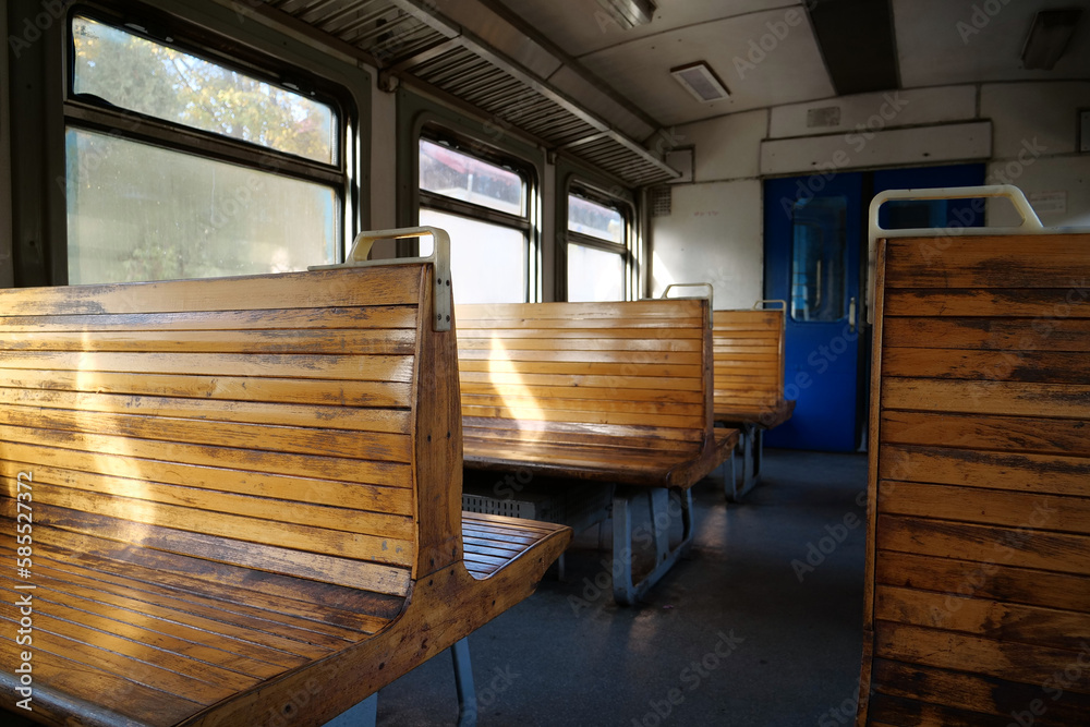 Old empty wagon of train. Wooden seats in an empty coach of train