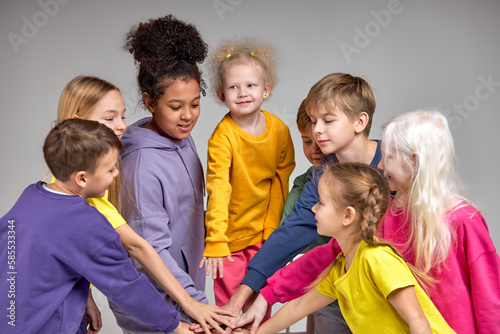 adorable kids joins their hands express their unity  friendship closeness  team is ready to take part in competition isolated white background