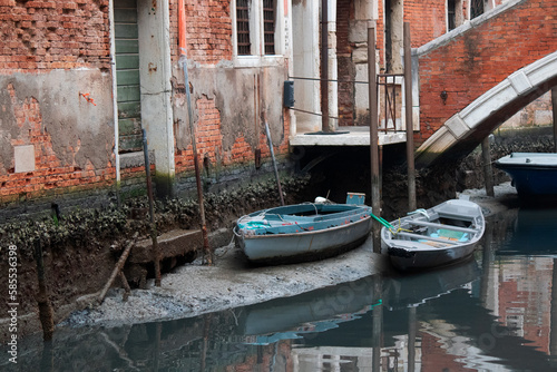 Boats in a canal in Venice with exceptionally low tide