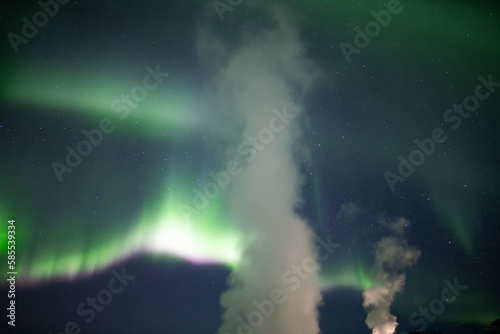 Aurora borealis behind geothermal steam Iceland