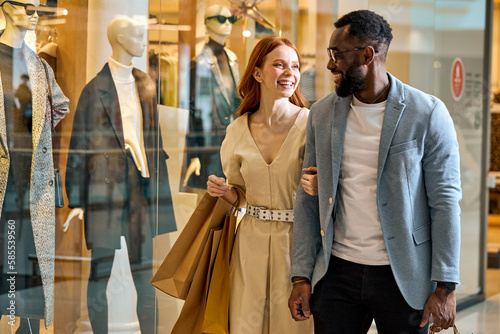 happy wife and husband spend their weekend at shopping mall. close up side view photo, cheerful couple strolling at shopping center , good mood, positive atmosphere between lovers