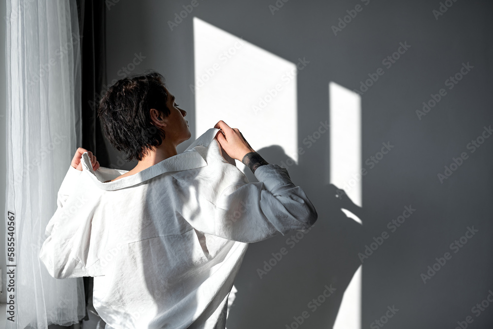 sexy black-haired businessman prepares for going to work, guy puts on white shirt. students going to institute, colleage in the morning. sexuality copy space. sexy black-haired businessman prepares for going to work, guy puts on white shirt. students going to institute, colleage in the morning. sexuality copy space.