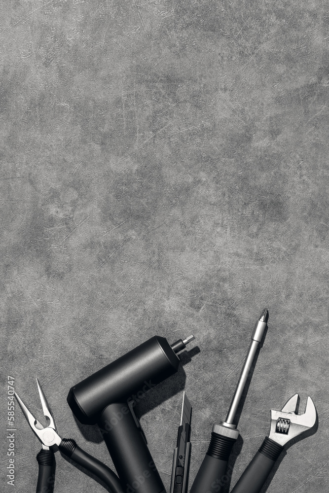 Naklejka premium Flat lay composition with set of home repair tools on grey stone background. Top view pattern with copy space.