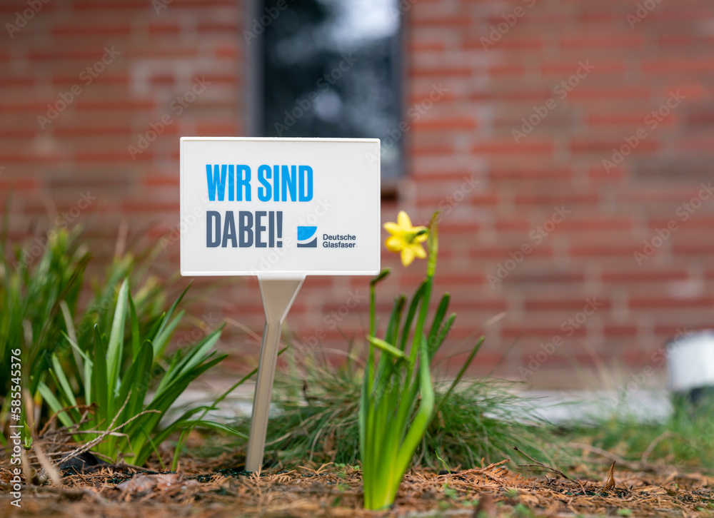Schild mit der Aufschrift 'Wir sind dabei, Deutsche Glasfaser' vor
