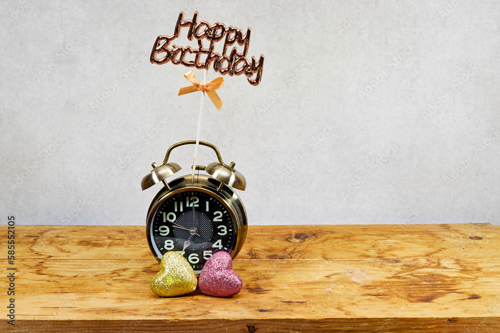 Alarm clock showing seven o'clock with heart glitters and happy birthday text Alarm clock showing seven o'clock with heart glitters and happy birthday text