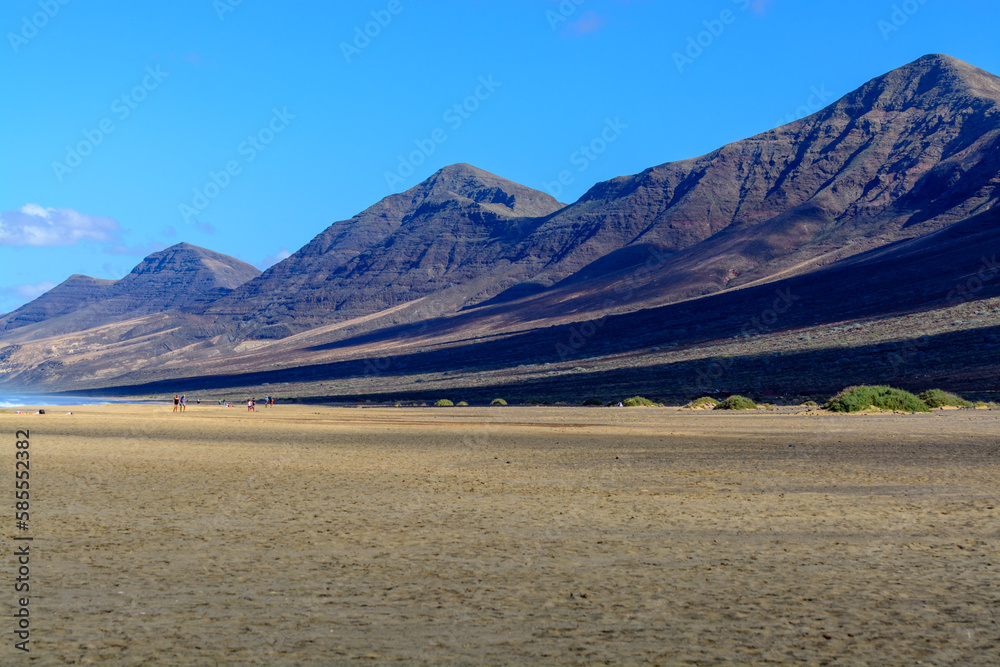 View on difficult to access golden sandy Cofete beach hidden behind mountain range on Fuerteventura, Canary islands, Spain