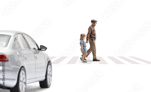 Full length profile shot of a grandfather crossing street with a child and car approaching