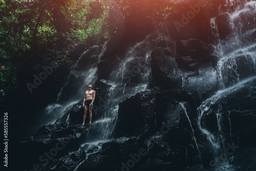 male standing at waterfall in Bali indonesia