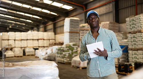 African american man manager leads the accounting of materials in a large warehouse