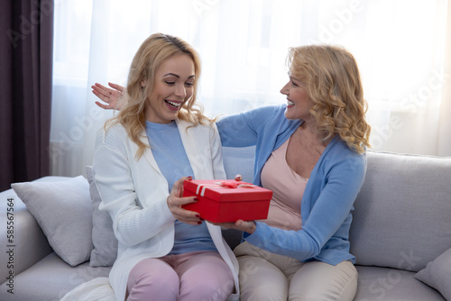 Happy daughter receiving a birthday present from her mother