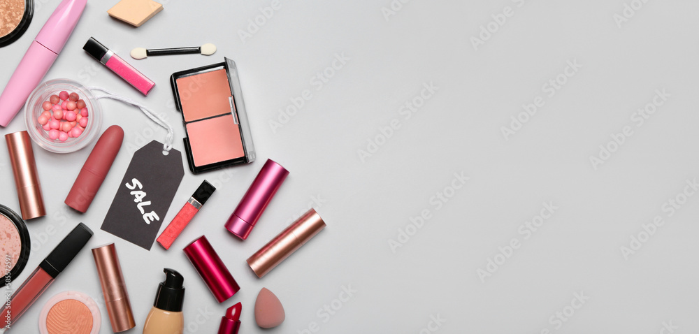 Set of makeup cosmetics and accessories for sale on grey background with space for text Set of makeup cosmetics and accessories for sale on grey background with space for text